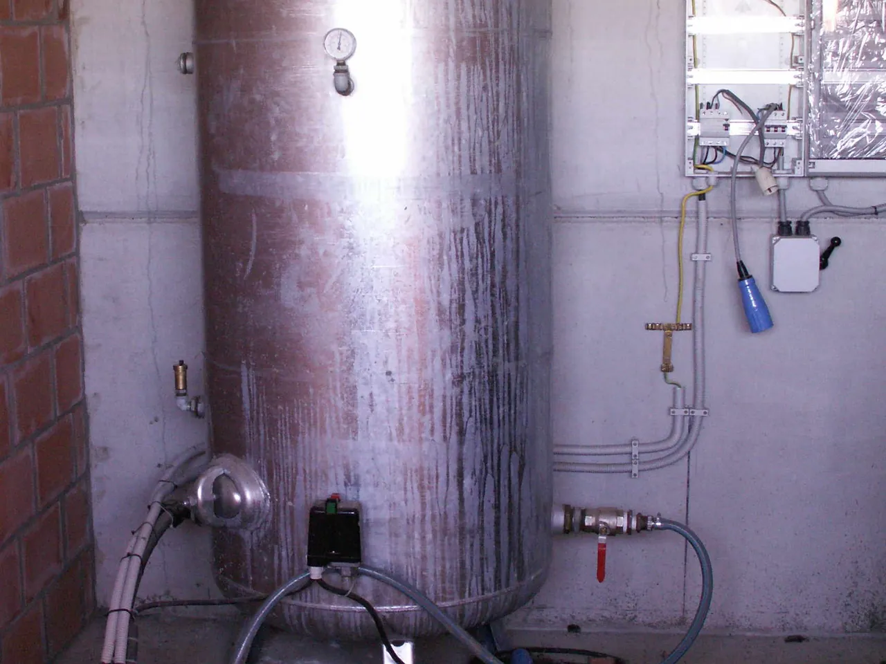 Air-over-water well pressure tank with its gauge and pressure switch in a pump room