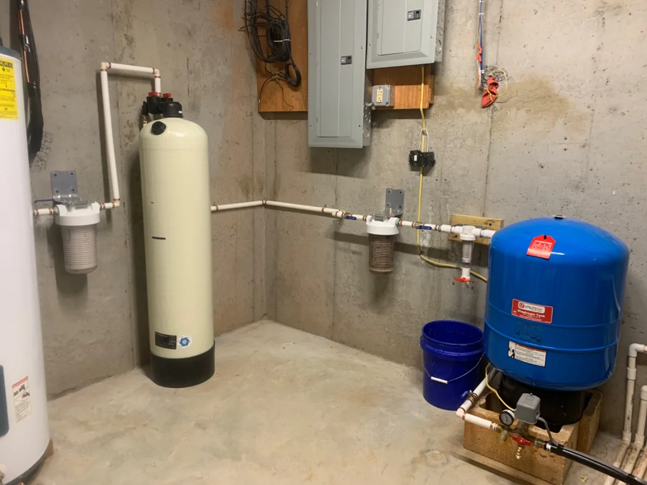 Acid neutralizer tank, sediment filters and pressure tank on a basement well water system